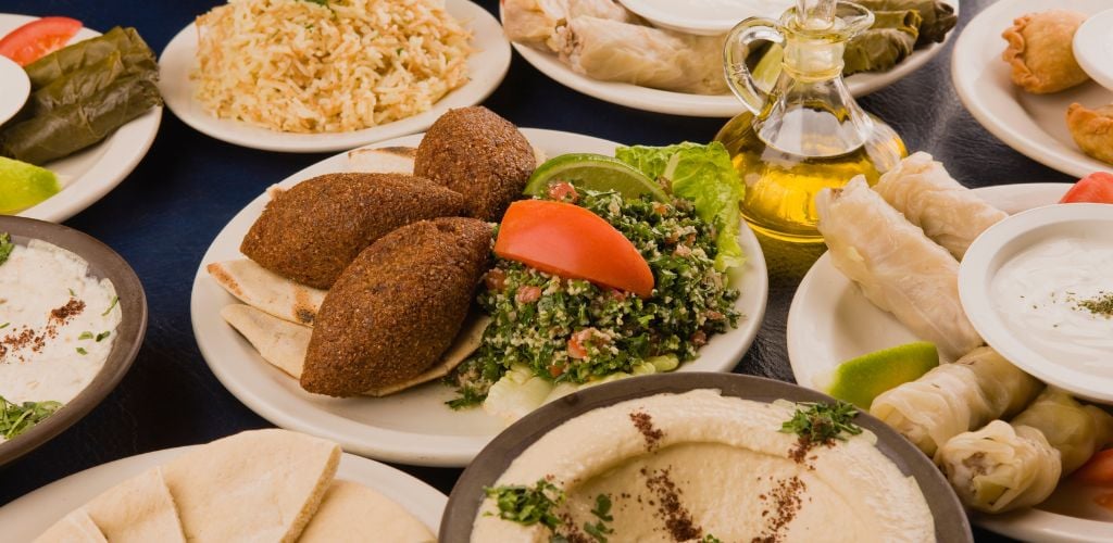 A table with a variety of Middle Eastern food, such as tabouleh.