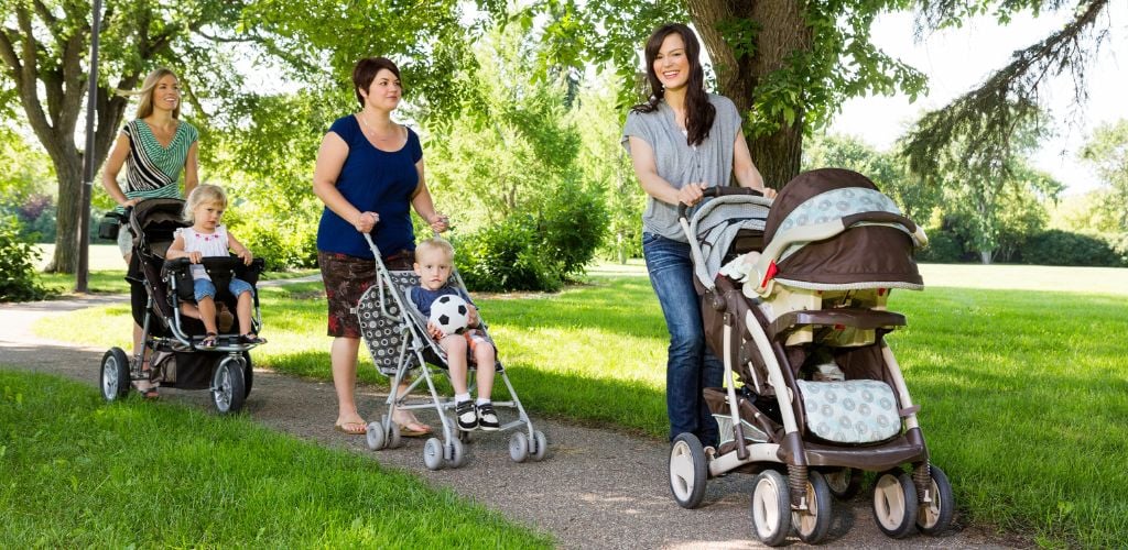 Parents on a boardwalk with their babies on strollers