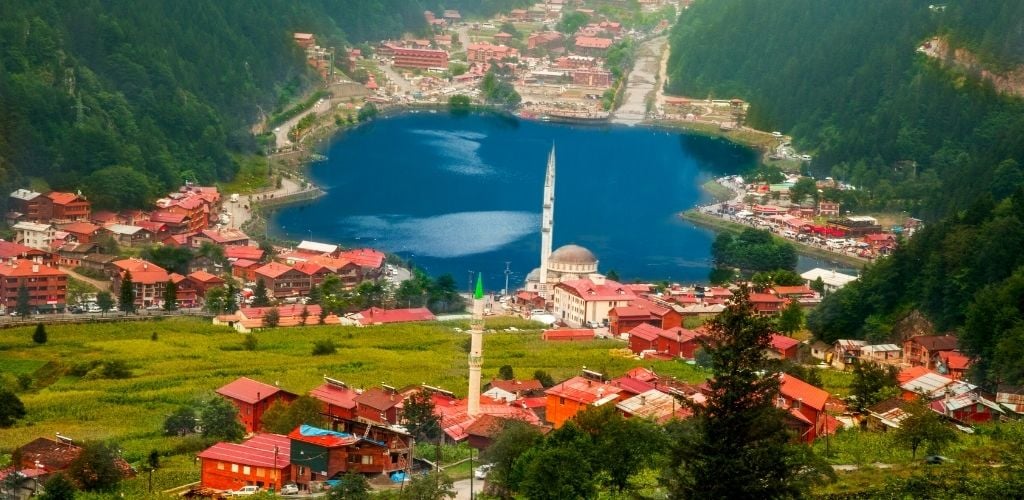 Trabzon, Turkey's Uzungol. A lake in the center is surrounded by a green mountain building structures. 