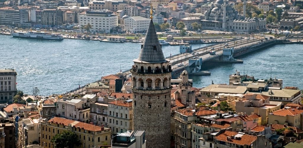 Galata Tower, Istanbul surrounded by building structure and there is a river.