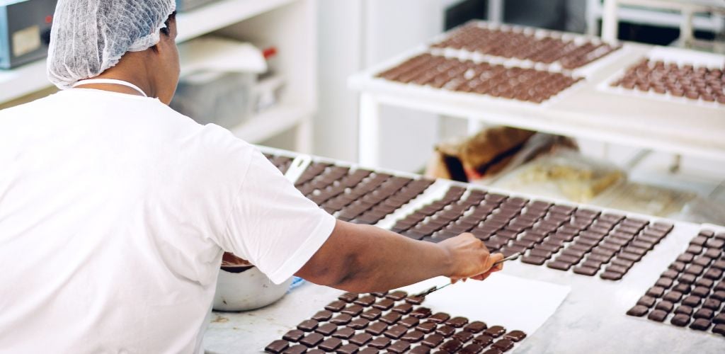 A crew member aligning chocolates 