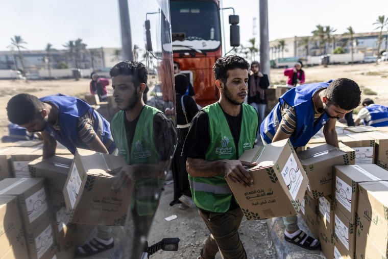 Volunteers load food and supplies onto aid convoy trucks for Gaza in Egypt.