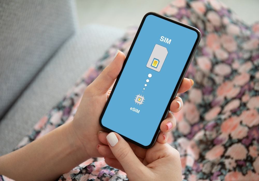 female hands hold phone with sim card replacement on eSIM