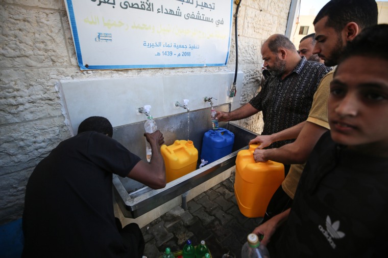 Palestinians fill water canisters in Deir al-Balah, central Gaza Strip, on Oct. 15, 2023. 