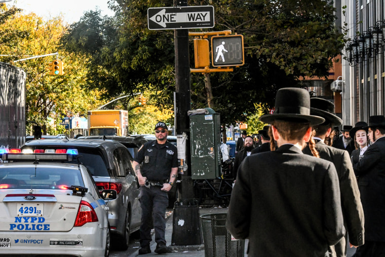 An NYPD officer patrols in front of the synagogue Congregation Bais Yaakov Nechamia Dsatmar in New York.