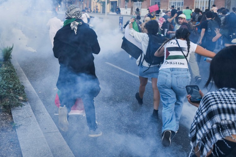 Protesters run to escape tear gas during an unauthorized demonstration in support of Palestinians in Toulouse, France.