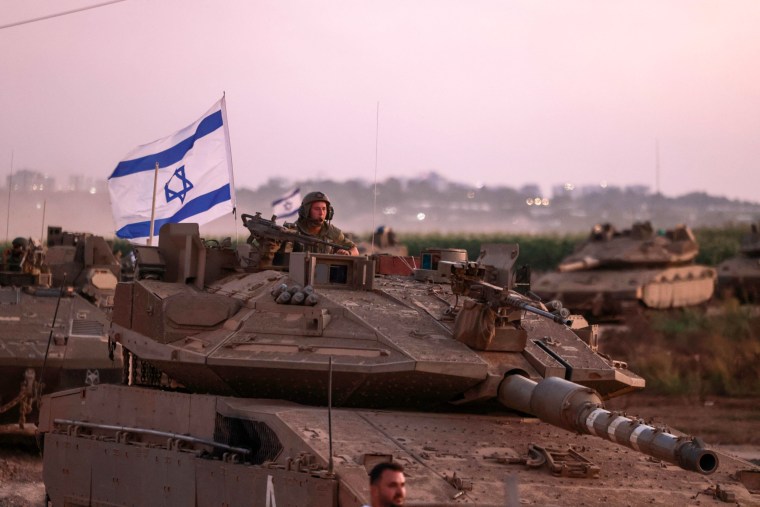 A convoy of Israeli armored vehicles advances near the border with Gaza on Oct. 12, 2023.