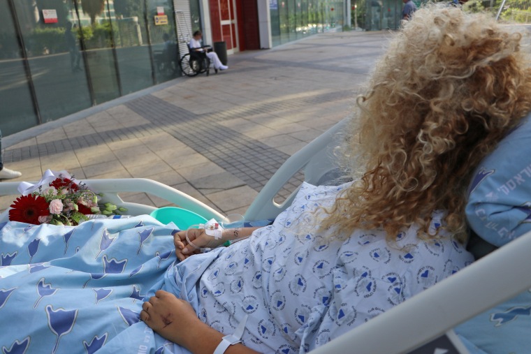 Marina Izmailov, 34, lies on a stretcher outside the Ichilov Hospital in Tel Aviv on Oct. 12, 2023.