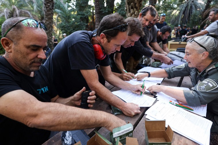 Israelis fill out forms to carry weapons at a kibbutz.