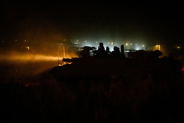 A column of Israeli tanks moves through the countryside in Kibbutz Re'im near the border with Gaza.