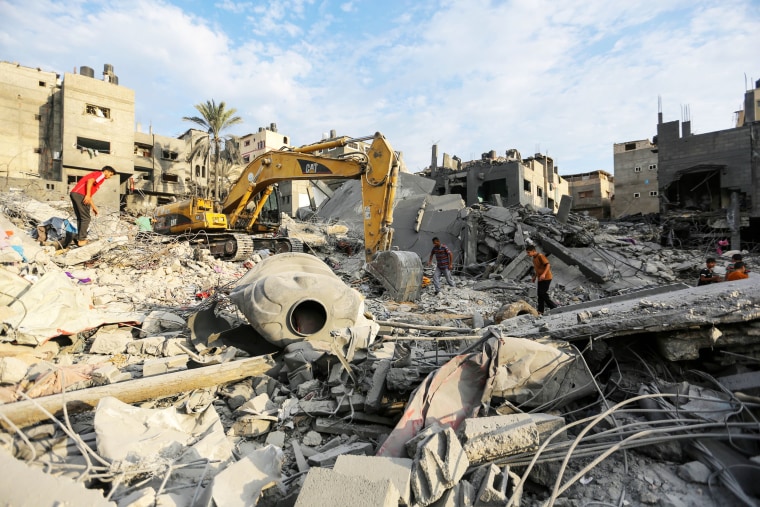 People search through buildings that were destroyed during Israeli air raids