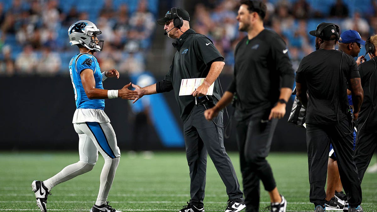 Bryce Young walks toward head coach Frank Reich