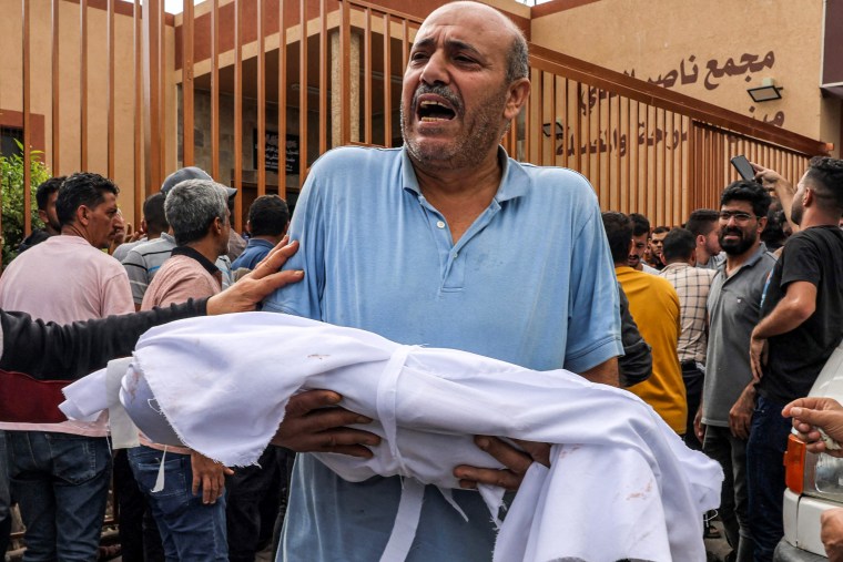 A man carries the body of a child killed in an Israeli airstrike in Gaza.