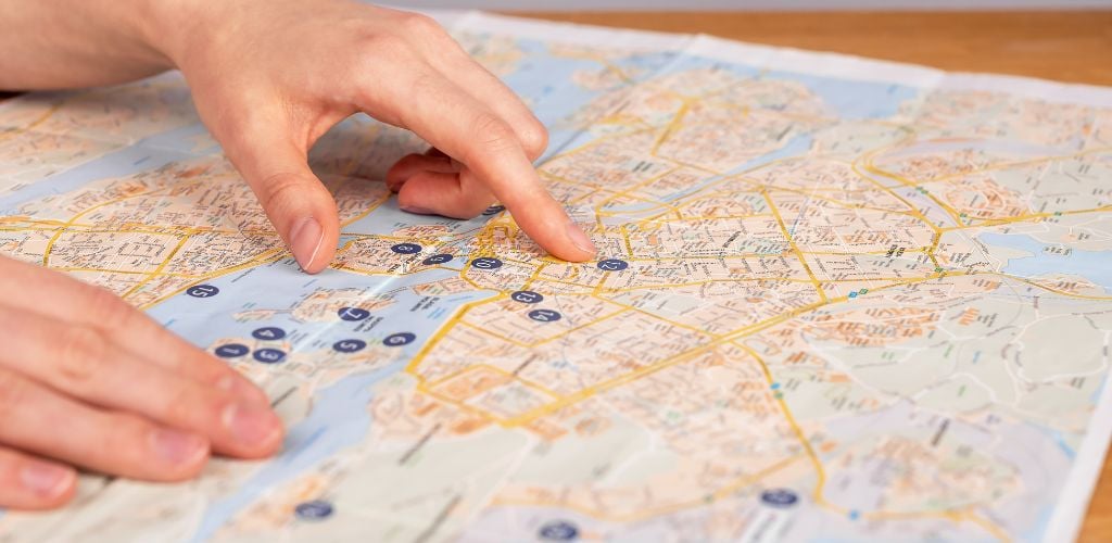 Hands on map. Woman studying travel itinerary.