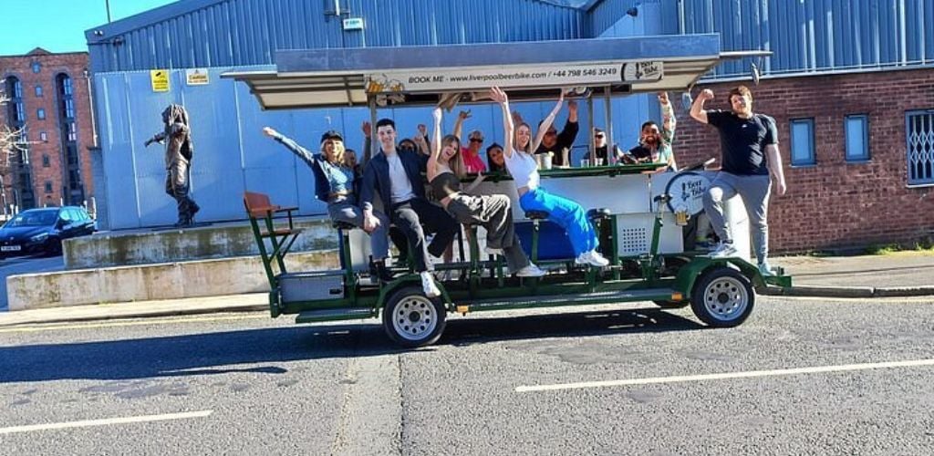 A group of tourists on a beer bike tour on the side of the road. 