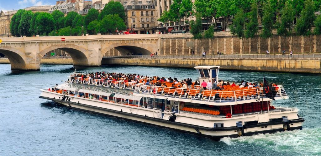 A boat tour in the river full of tourists. 