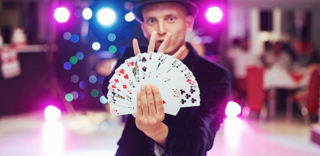Magician showing trick with playing cards. 