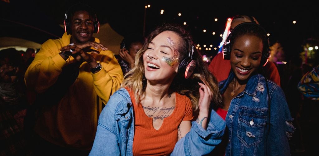 A young woman and man dancing at Silent Disco wearing a head set. 