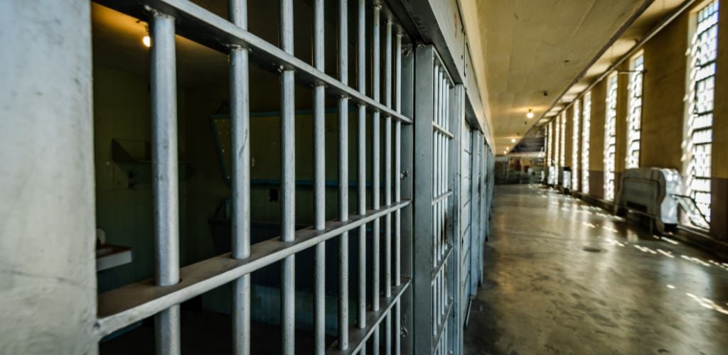 A hallway at the prison and a sun light from the outside of the big window. 