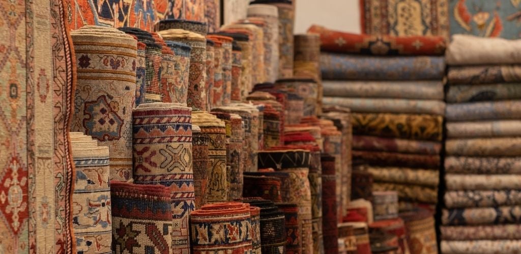 Rolls and Stacks of Vibrant Woven Carpets in a Store