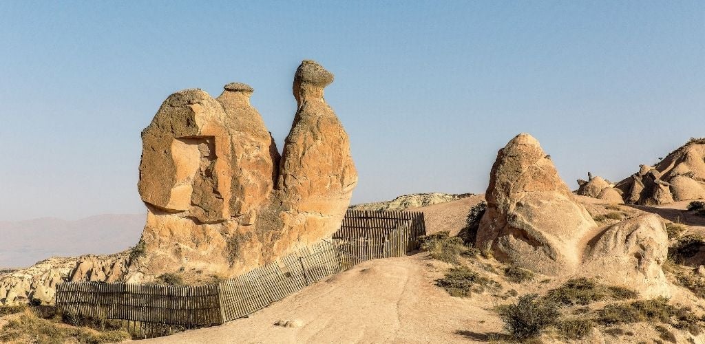 A tower-like rock formation with a triangle tip shape on top. 