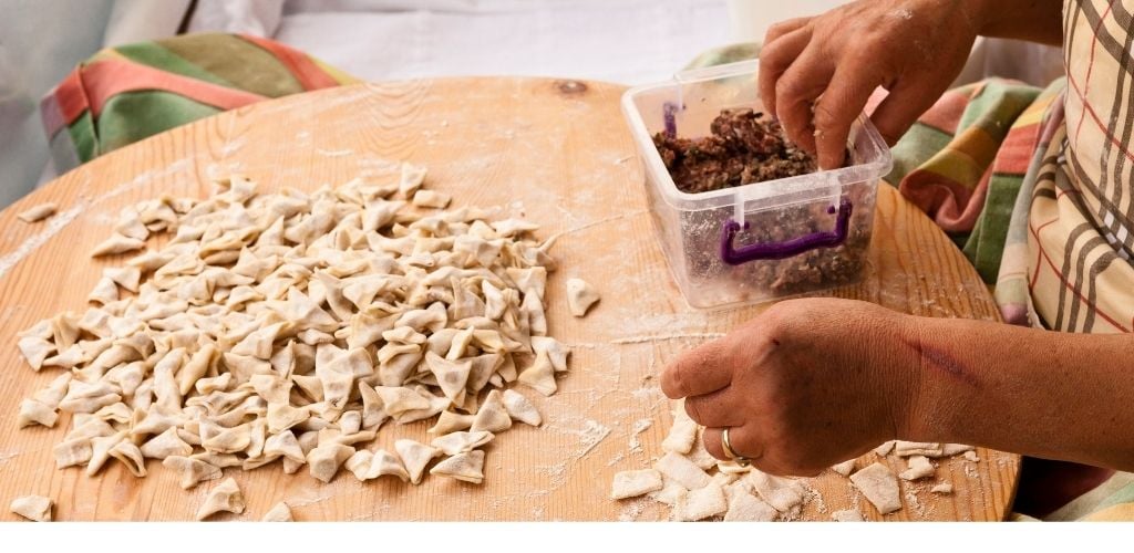 A classic Turkish dish being cooked is a triangle-shaped dough. 