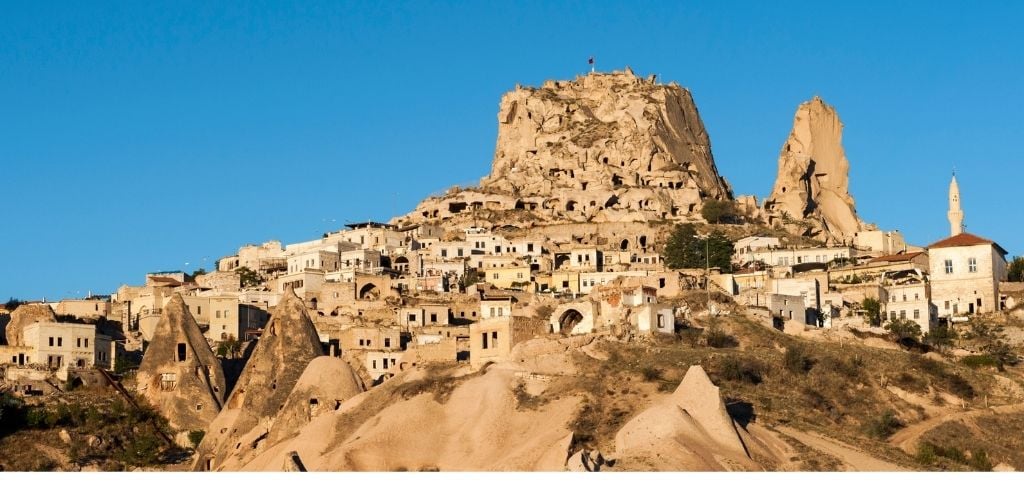 Ancient town and a castle of Uchisar dug from a mountains after sunrise, Cappadocia, Turkey. 