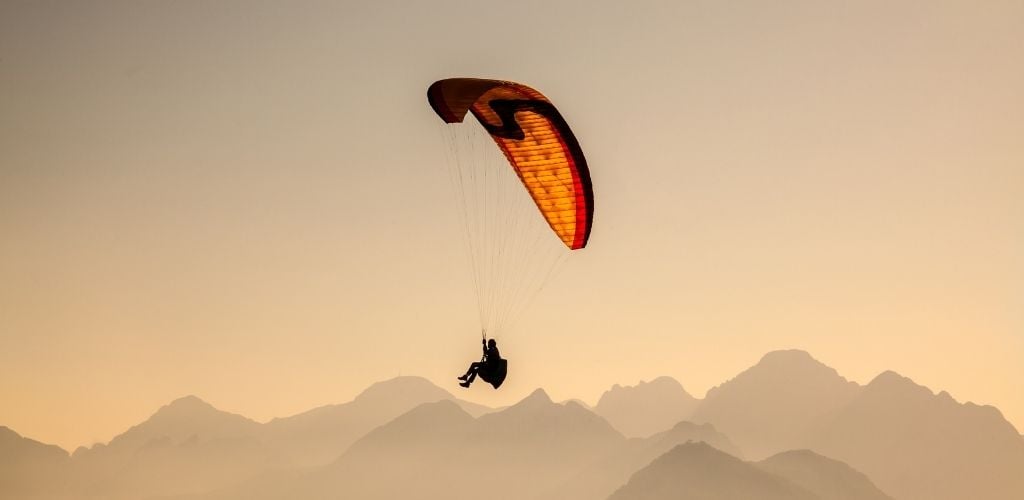 Paragliding, on sunset at above of the mountain. 