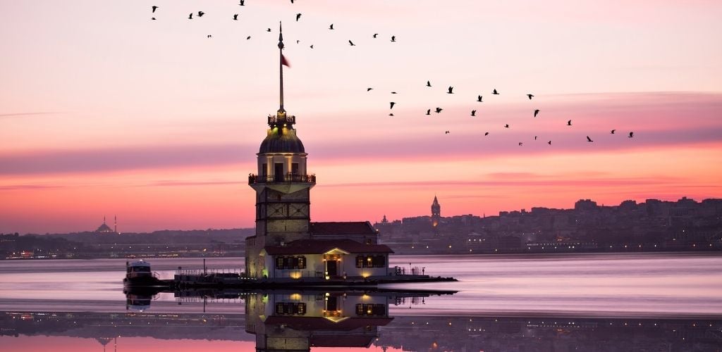 A tower on a small islet, A purple sky, and birds. 