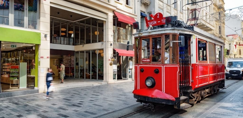 The Istanbul nostalgic tram on Istiklal avenue. The historic tram is a popular tourist attraction. Awesome view of the street on sunny day. 
