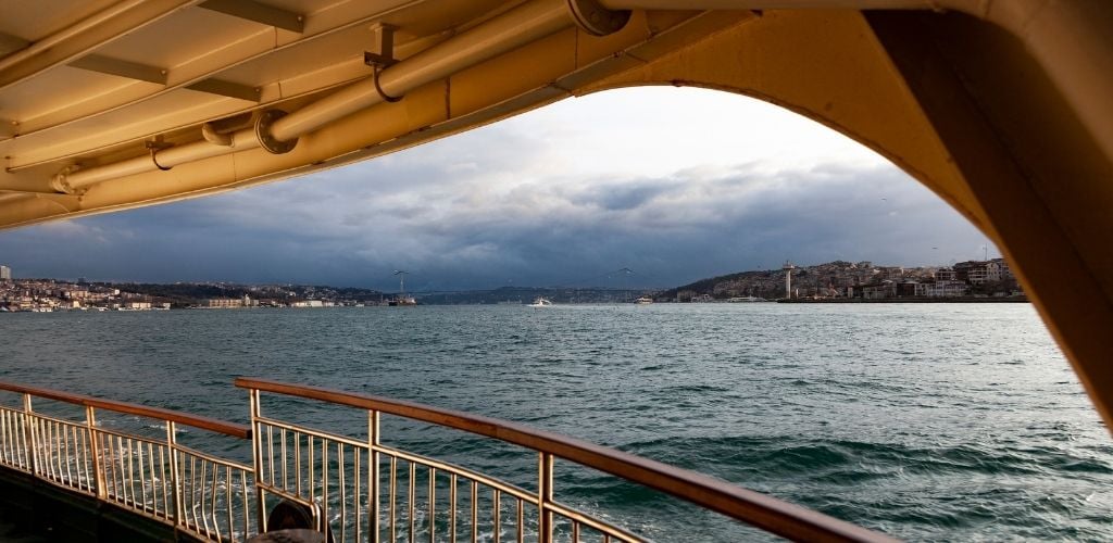 Blue sky clouds and blue waters on an autumn day in Istanbul. A stream of the Bosphorus Bridge from inside the island Stream boat floating in the Bosphorus. 