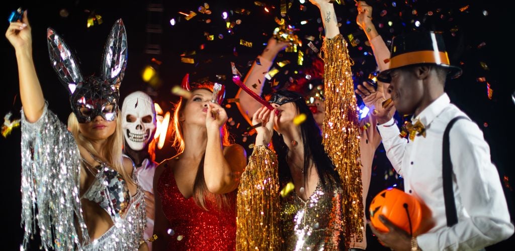 Happy people men and women mixed race dancing together on halloween party