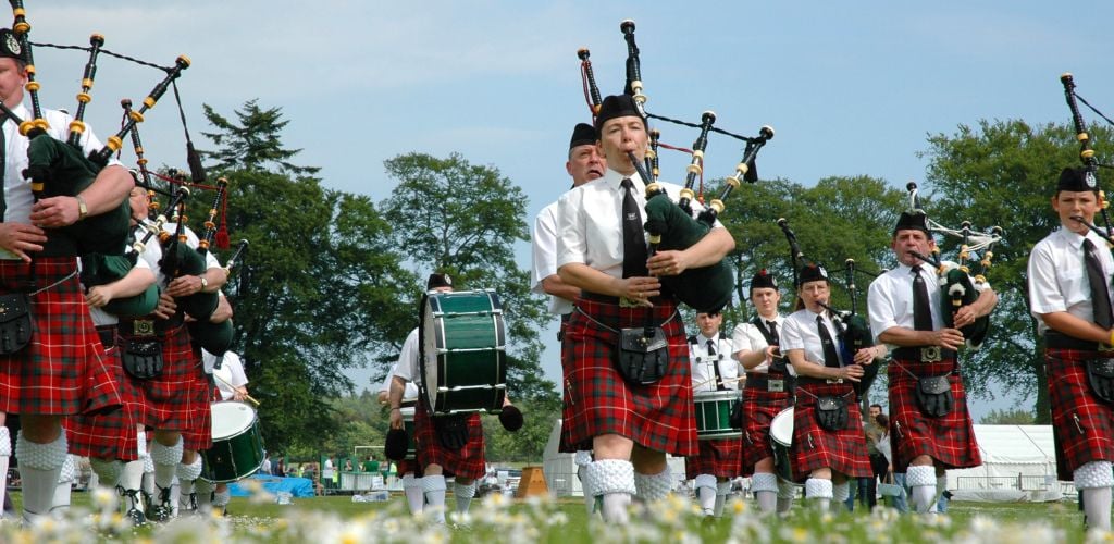 Marching Scottish band marchin' on grass.