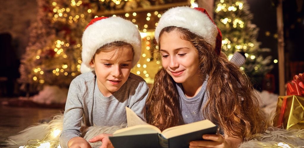 Children read a book in the room with Christmas decoration in Christmas.