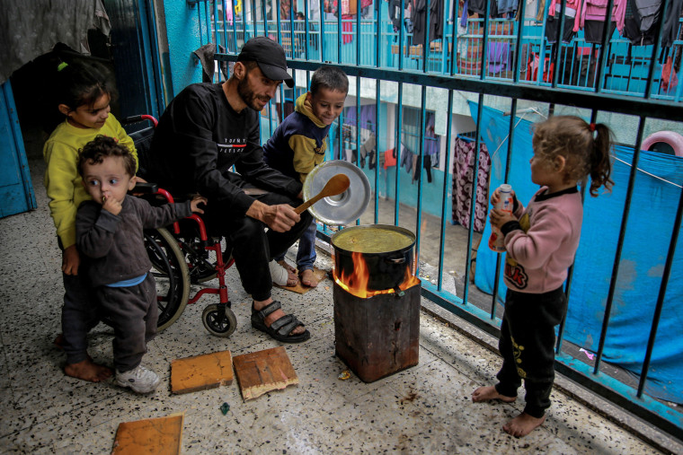 A Palestinian man cooks at a UNWRA school used as shelter in Gaza City on Nov. 27, 2023.