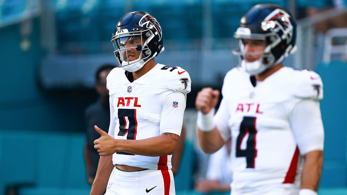 Desmond Ridder and Taylor Heinicke warm up before a game