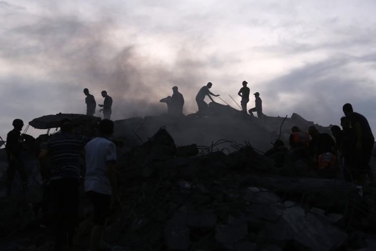 Palestinians conduct search and rescue operations at the