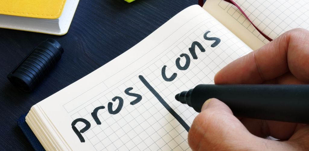 Man is writing list of pros and cons.