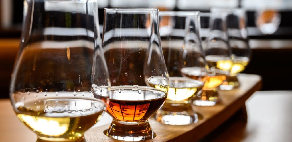 Scotch whisky, tasting glasses with variety of single malts or blended whiskey spirits on distillery tour in Scotland