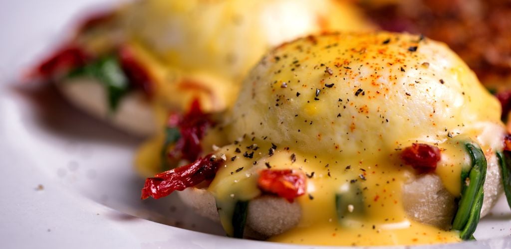 Fancy eggs benedict with sun-dried tomatoes and spinach.