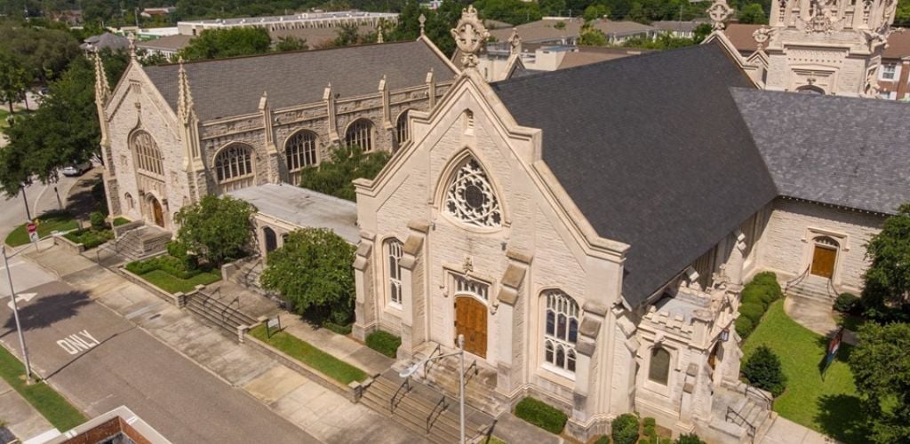 A St. John's Cathedral structure with a clean road, road lights, and lush plants decorate the church corners. 