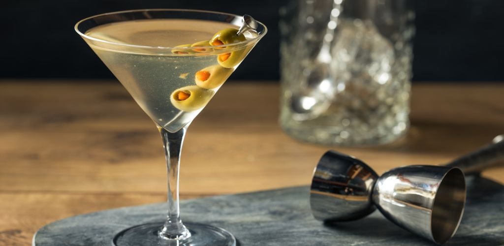 Boozy Traditional Dirty Martini with olive garnish. 