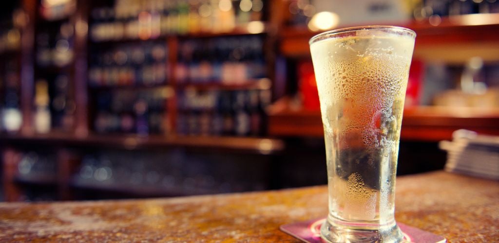 Cold Glass of Cider on Bar Counter in Irish Pub