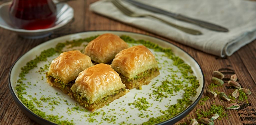 A sweet pastry made of layered phyllo dough, honey, and chopped pistachios and walnuts. 
