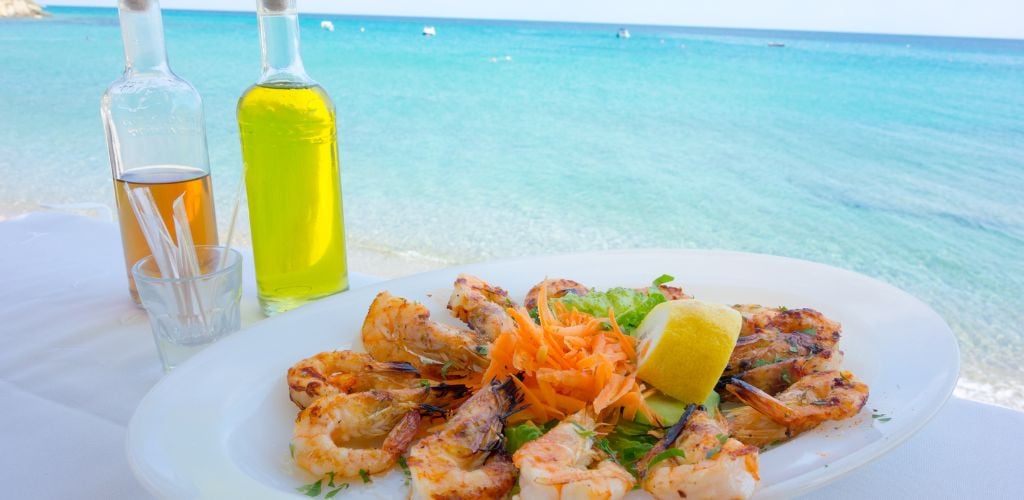 Various sea food and olive oil against blue sea. 