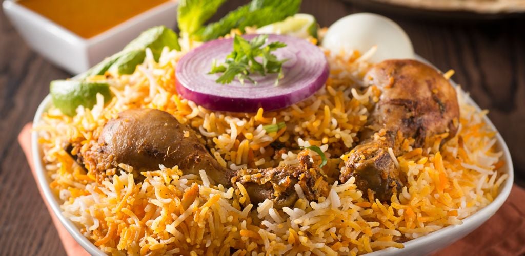 A Chicken Biryani with on ion on top. 