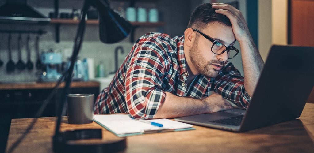 Young men struggle in front of a laptop at home at night. 