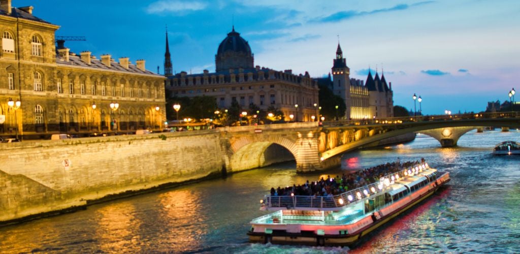 Bateau Mouche at Night along the Seine River and cruise full of tourist. 