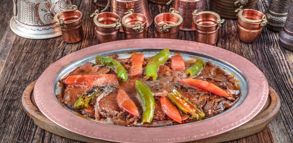 Traditional Turkish Doner Kebab also known iskender. Iskender kebab (iskender kebap). Turkish style doner kebab food on wooden table background.