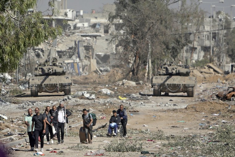 Palestinian men flee to northern Gaza as Israeli tanks block the Salah al-Din road in the central Gaza Strip on Nov. 24, 2023.